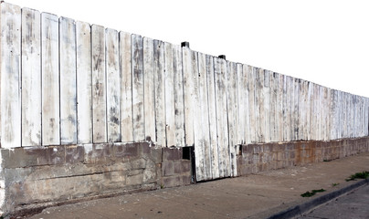 Weathered grungy white washed fence in need of a new coat of paint.