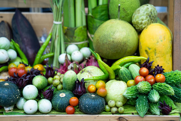 Pile vegetables at wooden shelf.