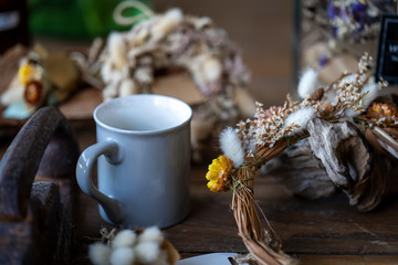 cup coffee at decorative flower on wooden table.