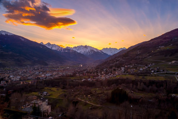 Panorama of Aosta city at sunset, with mountains on background and colorfull sky