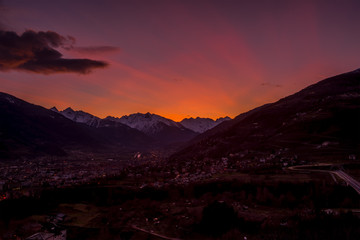 Panorama of Aosta city at sunset, with mountains on background and colorfull sky