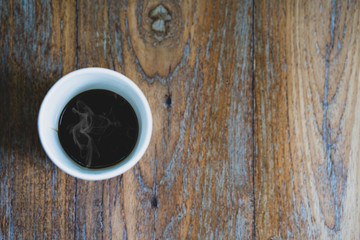 Cup coffee on textured wooden table.