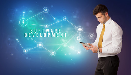 Businessman in front of cloud service icons with SOFTWARE DEVELOPMENT inscription, modern technology concept