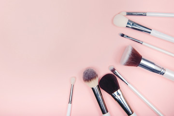 Set makeup brushes on pink color background. Top view point, flat lay