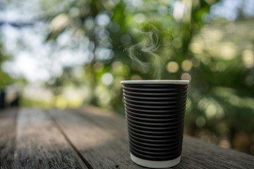 cup coffee with smoke on wooden table.