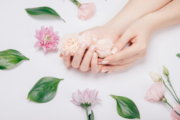 Concept beauty skin care. Beautiful stylish trendy female pink manicure with flower on background, top view