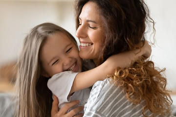 Closeup view beautiful young mother snuggle little cheerful daughter