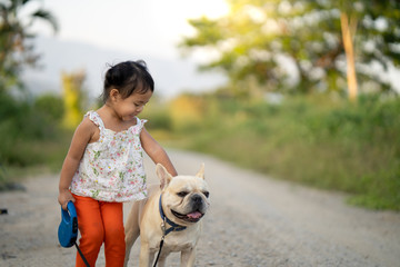 Little girl with dog walking on the road 