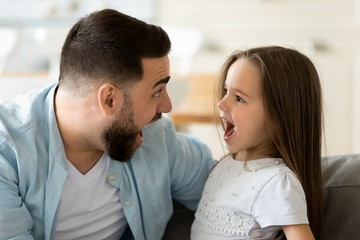 Funny dad and daughter looking at each other having fun