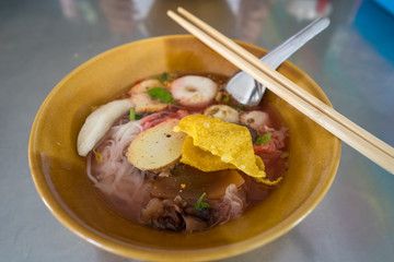 Pink seafood Noodle Soup on stainless table.