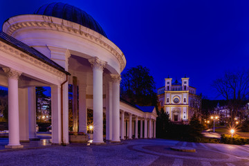 Colonnade of the mineral water springs and catholic church at evening - Marianske Lazne (Marienbad) - great famous Bohemian spa town in the west part of the Czech Republic