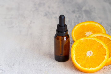 Fresh orange fruit and orange essential oil on concrete background. Natural medicine and Ayurvedic treatment.