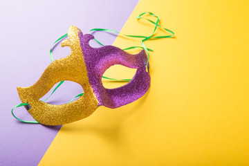 A festive, colorful group of mardi gras or carnivale mask on a yellow purple background. Venetian masks.