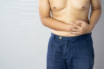 Naklejka premium Portrait of man holding his stomach from the pain.