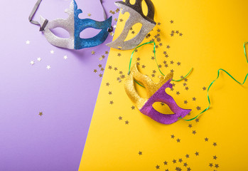 A festive, colorful group of mardi gras or carnivale mask on a yellow purple background. Venetian...