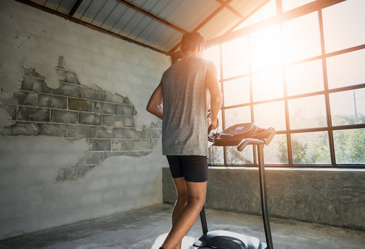 Asian man in sportswear running on treadmills in modern fitness center.Exercise and recreation concept.