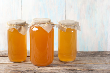 Kombucha tea in glass canister on wooden background