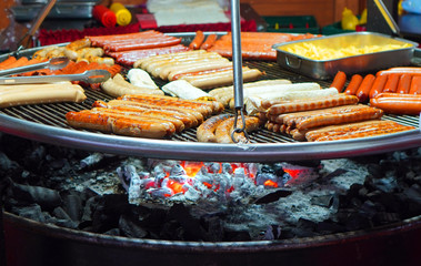 Street food background with assortment of grilled sausages