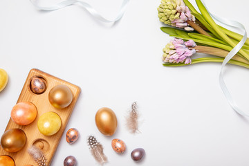 Top-down view of Gold colored Easter eggs with copy space for text on white background, flat lay design