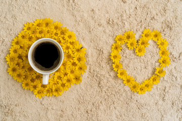 cup coffee on Sphagneticola trilobata flowers