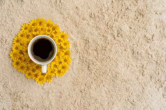 cup coffee on Sphagneticola trilobata flowers