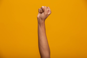 Woman hand sign on yellow background.