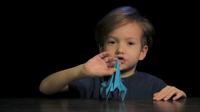 Boy play with paper rocket toy, childhood concept, child travel.