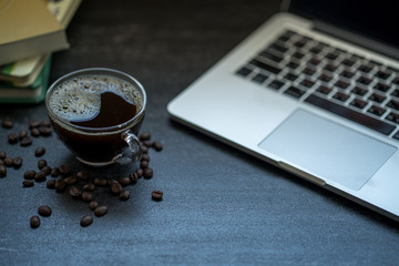 Cup coffee on black tiled table.