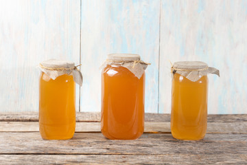 Kombucha tea in glass canister on wooden background