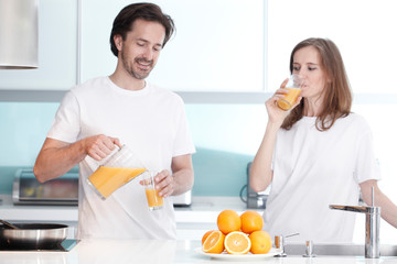 Obraz na płótnie Canvas Couple with juice in the kitchen