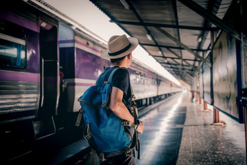 Travelers, Asian male backpackers with cameras standing at the train station and waiting for tourist trains