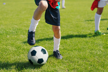 Young Soccer Player with Classic White and Black Ball on the Green Grass Soccer Pitch