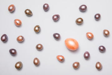 Colorful pastel Easter eggs background with gold and orange eggs. Top-down view, flat lay