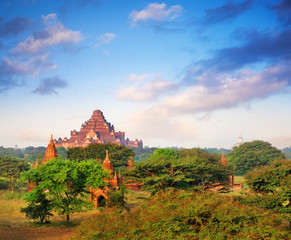 Colorful sky above temples surrounded by green vegetation in old Bagan, Myanmar.