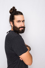 profile of hipster beard man looking at camera with thoughtful expression. Standing against white background.