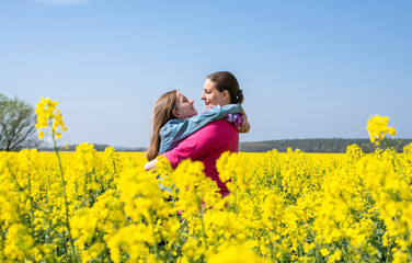 Fototapeta premium Mutter und Tochter im Rapsfeld