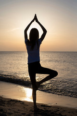 Fototapeta na wymiar junges Mädchen macht Yoga am Meer