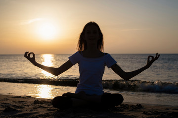 junges Mädchen macht Yoga am Meer