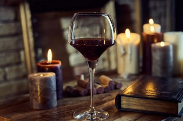 Glass of red wine with candle lights.