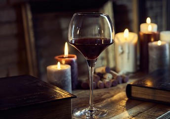 Glass of red wine with candle lights.