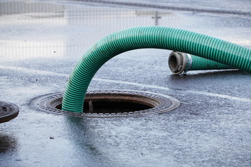 the green thick hose from a sewer pit, pumping sewage or sewage from collector in city. water...