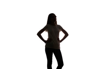 Young girl stands and holds hands on belt - silhouette