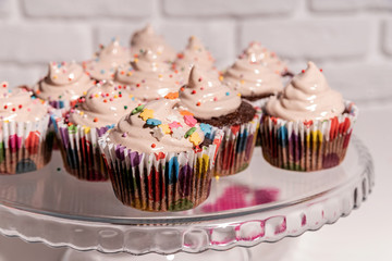 birthday cupcakes with colorful decorations on cake plate