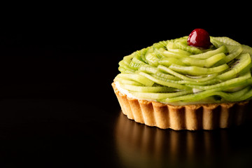 Tart with kiwi and whipped cream on black background wipes