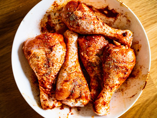 Marinated raw chicken drumsticks ready for grill