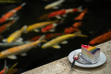 Colorful cake on marble seat along the carp fish tank.