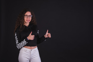 Young girl model posing with cute racing sweater in black background