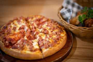 Peperoni pizza on wooden bowl.