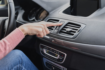 Woman hand press the emergency stop button in the car