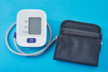 Digital blood pressure monitor on a blue background, closeup. Helathcare and medical concept